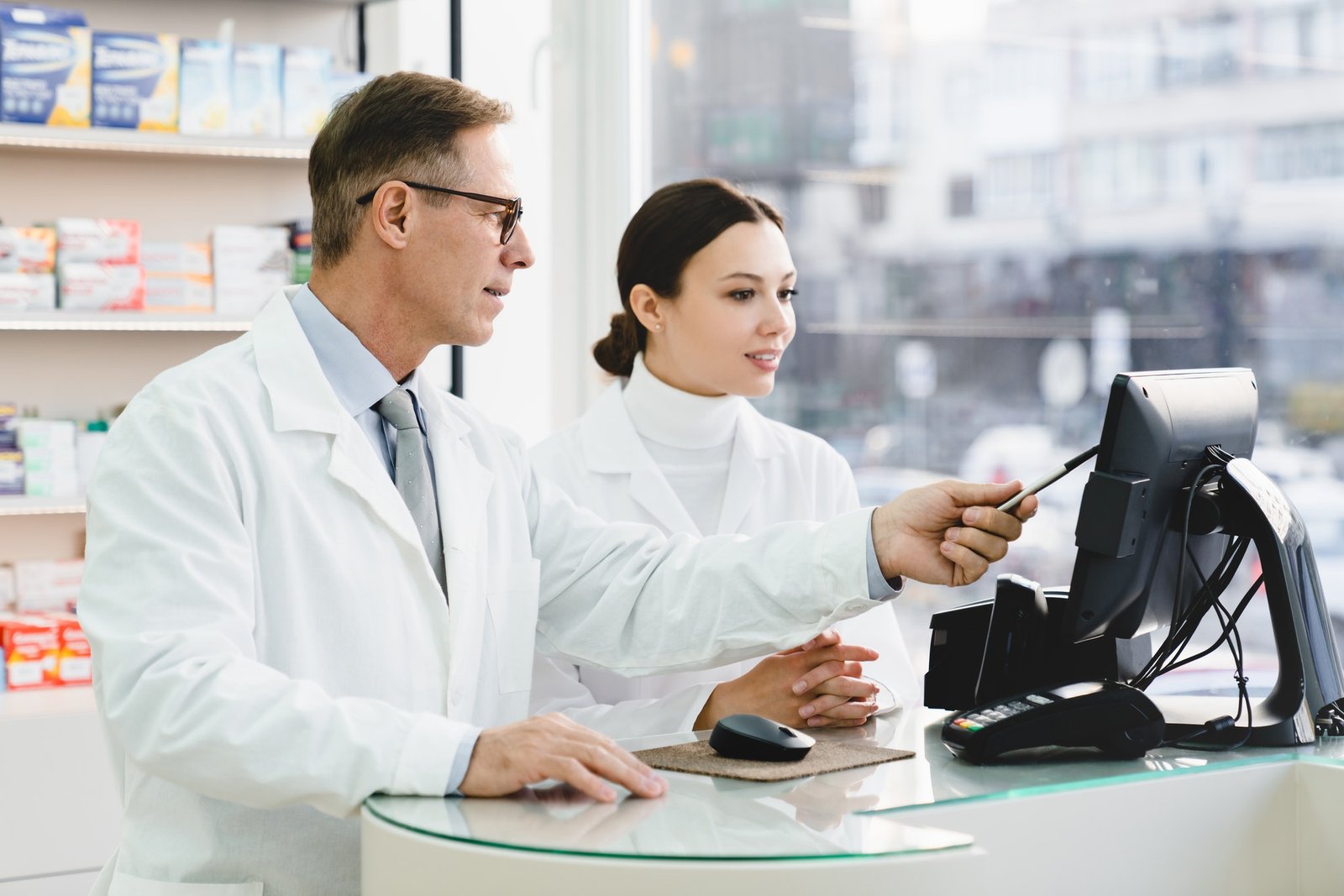 pharmacist-pointing-showing-male-colleague-medication-prices-prescriptions-on-computer-screen.jpg
